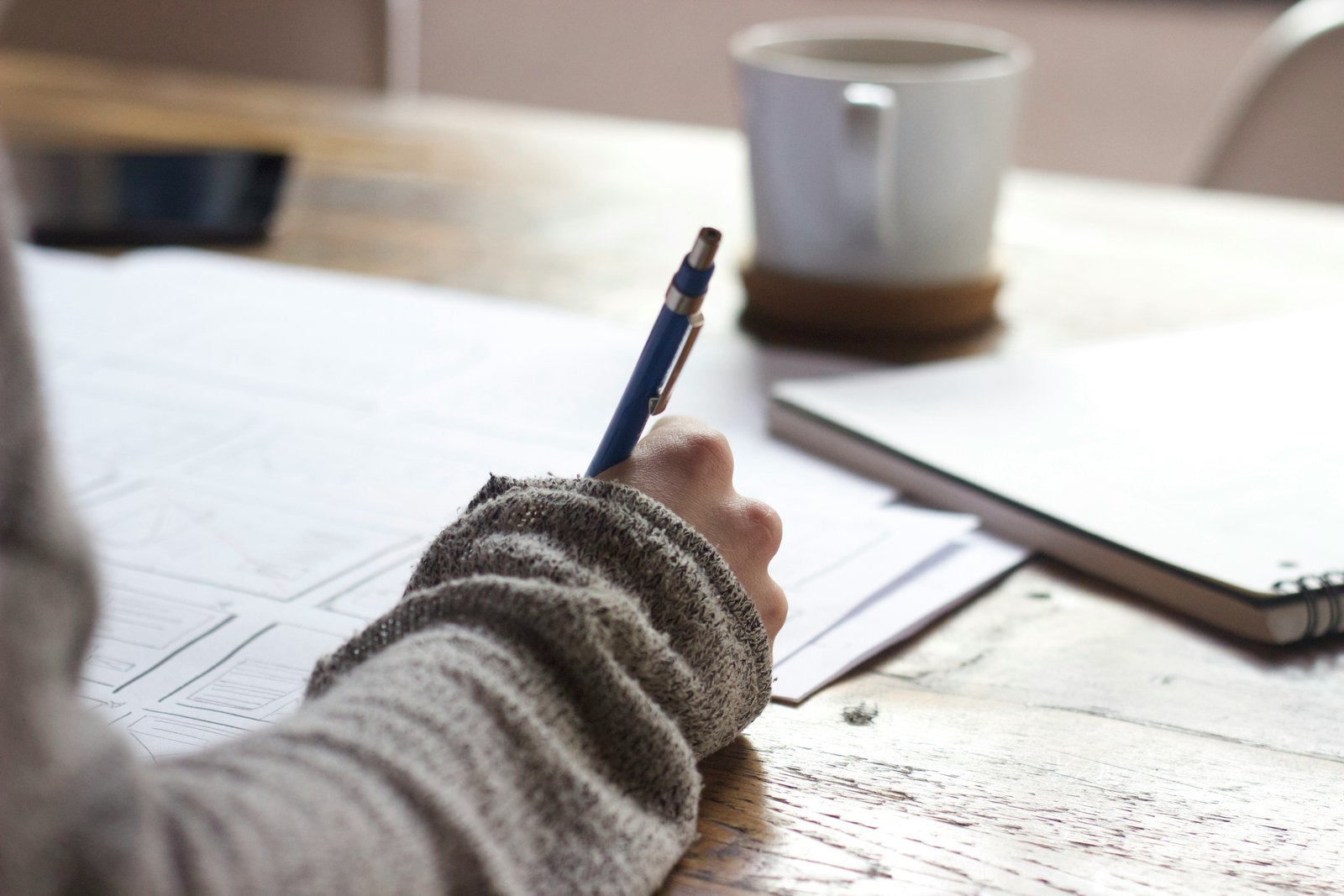 A handwritten draft and pen on a desk