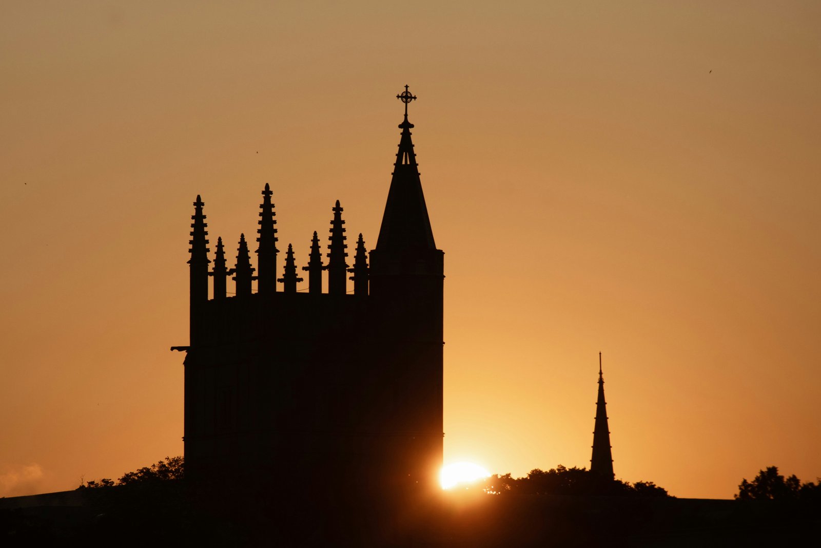 A college spire silhouetted at sunset