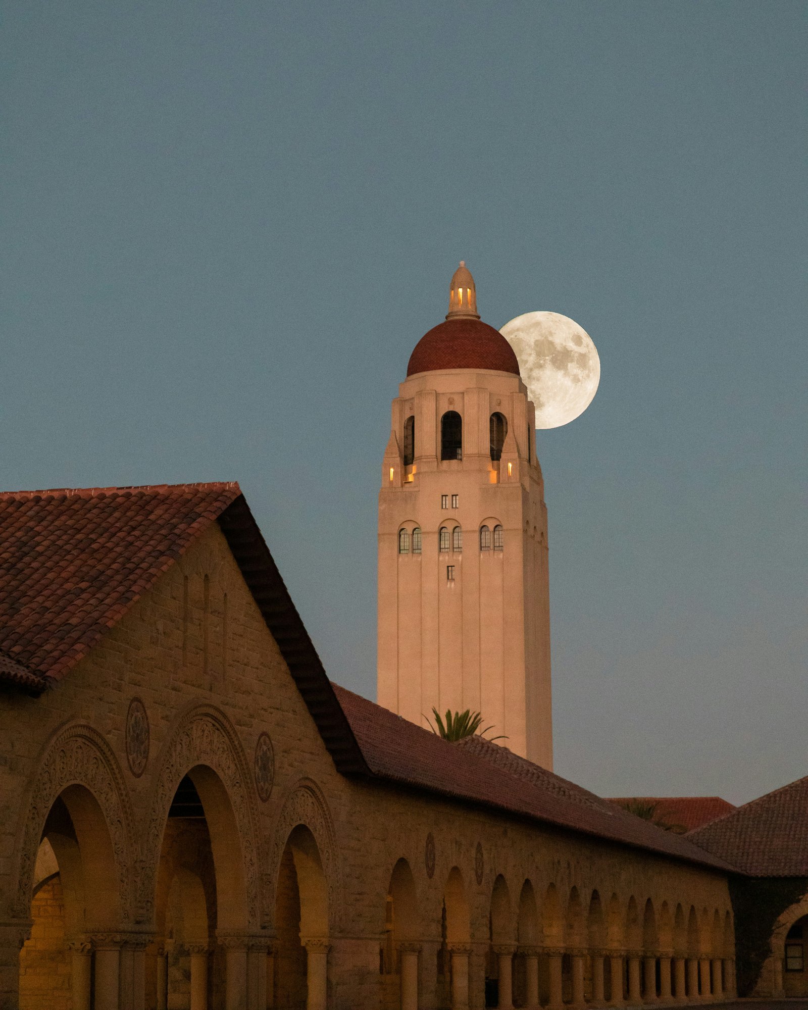 A campus clock tower at moonrise